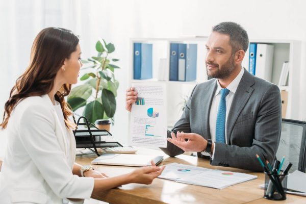 handsome-advisor-discussing-document-with-investor-at-office handsome-advisor-discussing-document-with-investor-at-office
